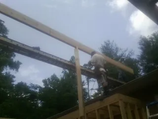 Carpenter setting a ridge beam over a new addition frame — Ice Dam Removal by Roofing Brothers in Elizabethtown
