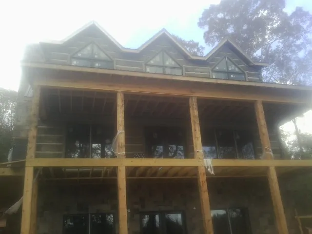Dormers and porch framing on a large log home under construction — Roof Coating work by our crew in Elizabethtown